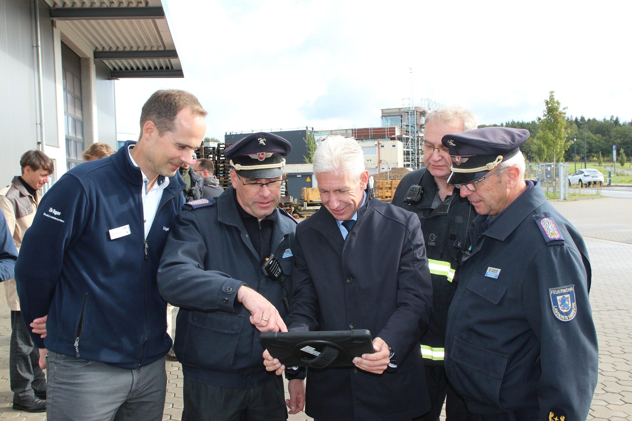 Mehrwert für die Feuerwehren durch 5G: (von links) Dräger-Projektleiter Timm Wallrodt und Torsten Lorenzen erläutern Landrat Rainer Rempe, Volker Kleeblatt und Kreisbrandmeister Volker Bellmann das Einsatzunterstützungssystem. (c) Landkreis Harburg